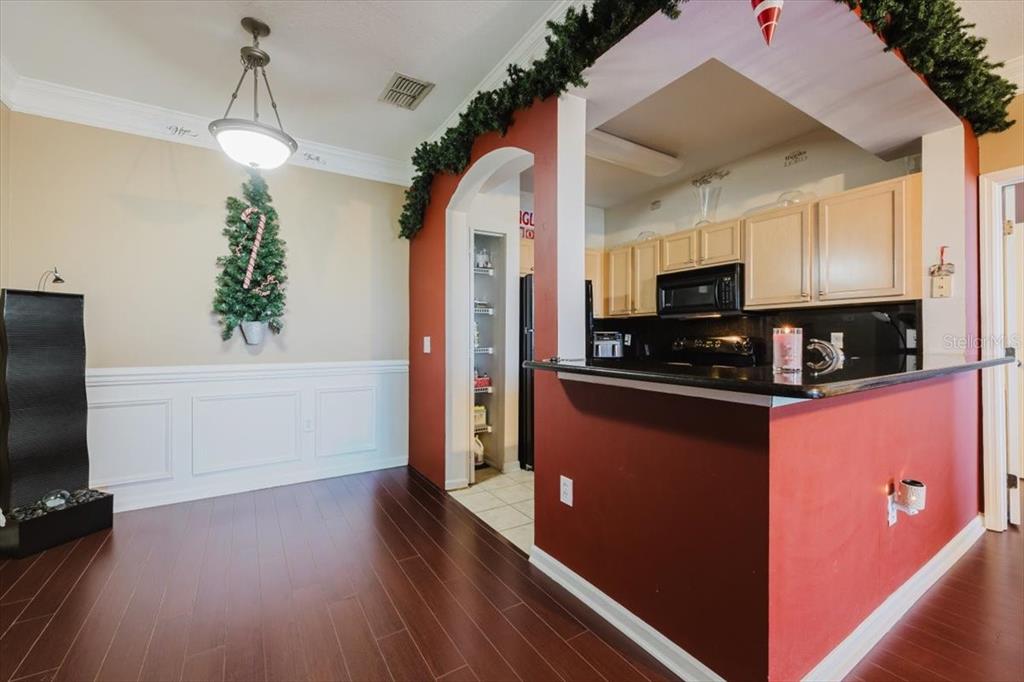 12849 Madison Pointe Circle, Unit 307 Orlando, FL 32821 - Photo 8 of 25 a kitchen with stainless steel appliances granite countertop a refrigerator a stove a microwave oven a sink dishwasher and white cabinets with wooden floor