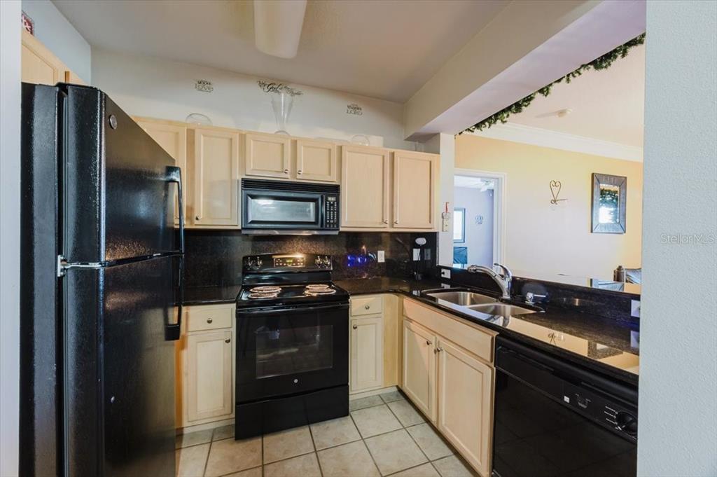12849 Madison Pointe Circle, Unit 307 Orlando, FL 32821 - Photo 9 of 25 a kitchen with a sink stove and refrigerator
