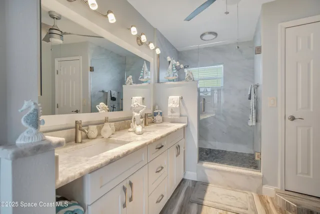 a spacious bathroom with a granite countertop sink mirror and shower