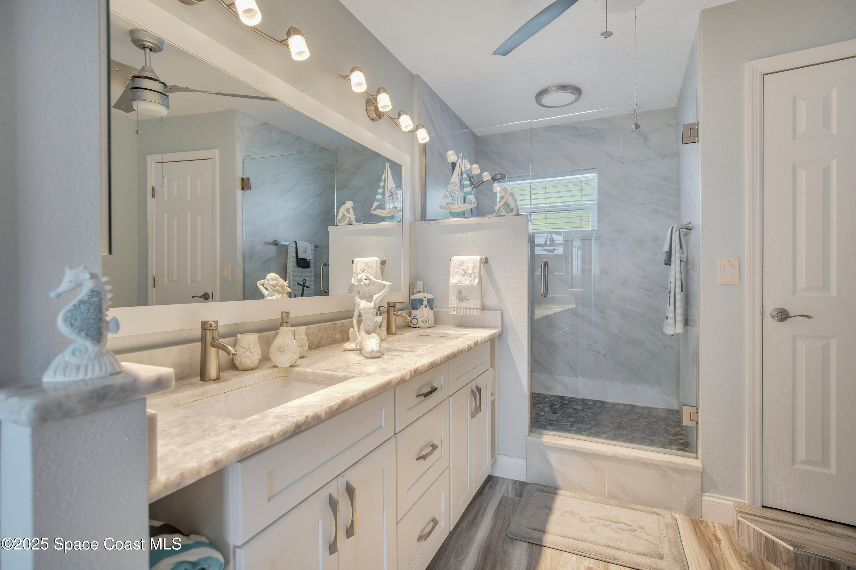 4000 Ocean Beach Boulevard, Unit 5C Cocoa Beach, FL 32931 - Photo 12 of 32 a spacious bathroom with a granite countertop sink mirror and shower