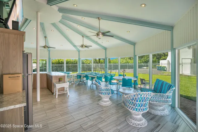 a kitchen with a table chairs refrigerator and outdoor view