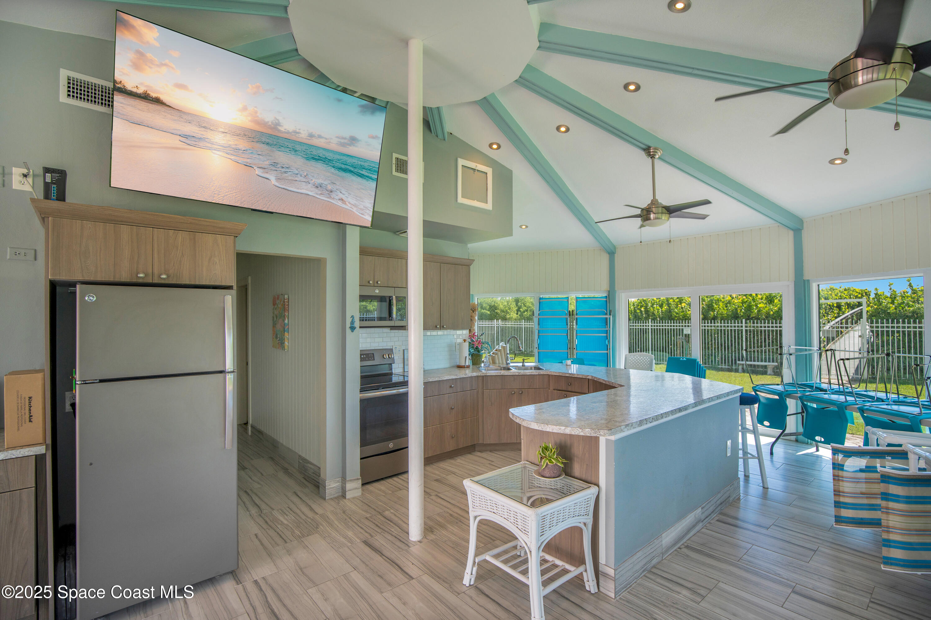 4000 Ocean Beach Boulevard, Unit 5C Cocoa Beach, FL 32931 - Photo 19 of 32 a kitchen with a table chairs refrigerator and outdoor view