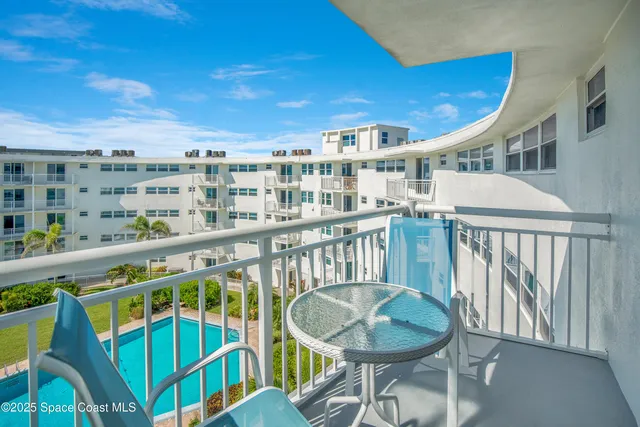 a balcony with table and chairs