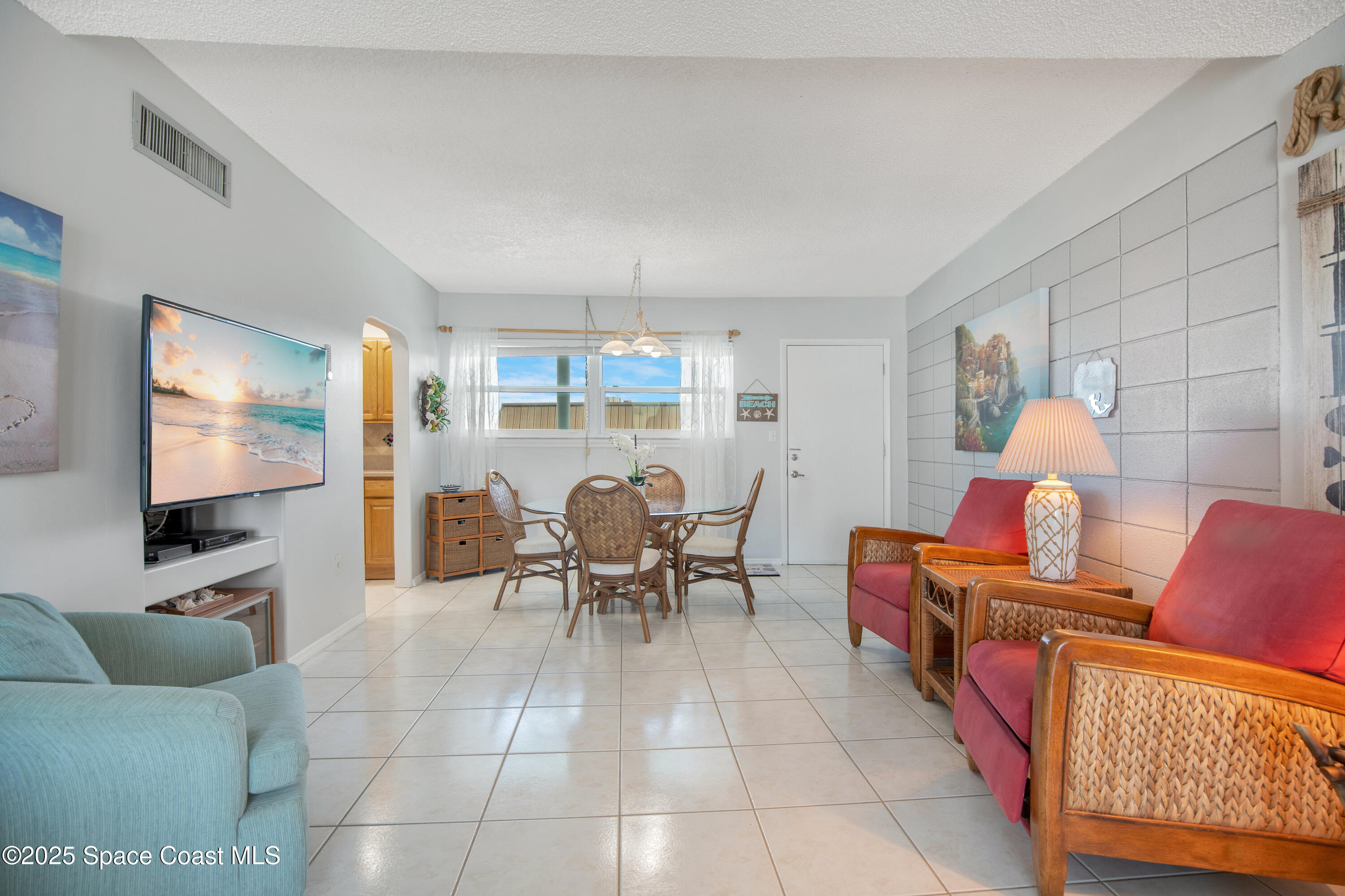 4000 Ocean Beach Boulevard, Unit 5C Cocoa Beach, FL 32931 - Photo 5 of 32 a living room with furniture and a flat screen tv