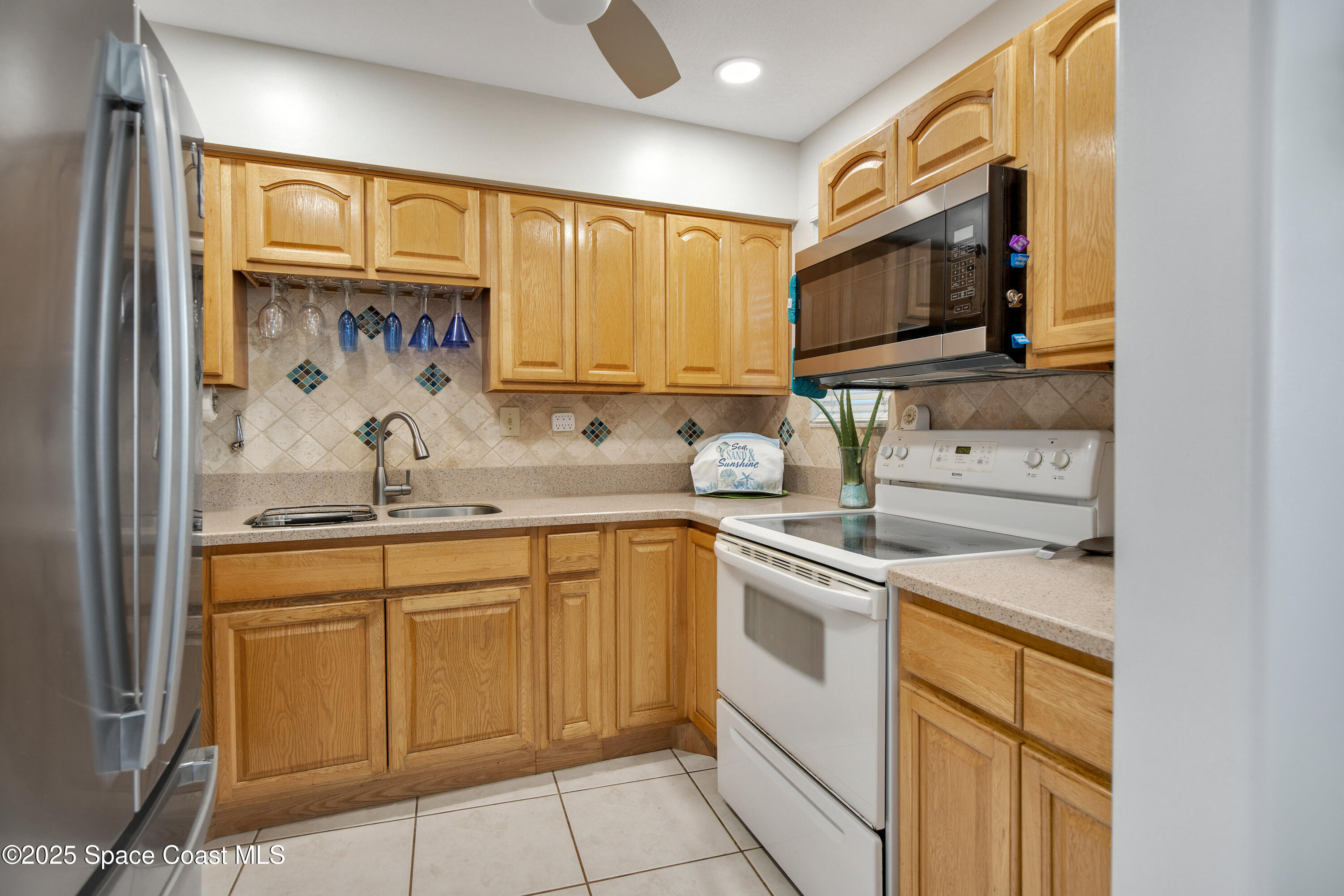 4000 Ocean Beach Boulevard, Unit 5C Cocoa Beach, FL 32931 - Photo 9 of 32 a kitchen with stainless steel appliances granite countertop a sink and cabinets