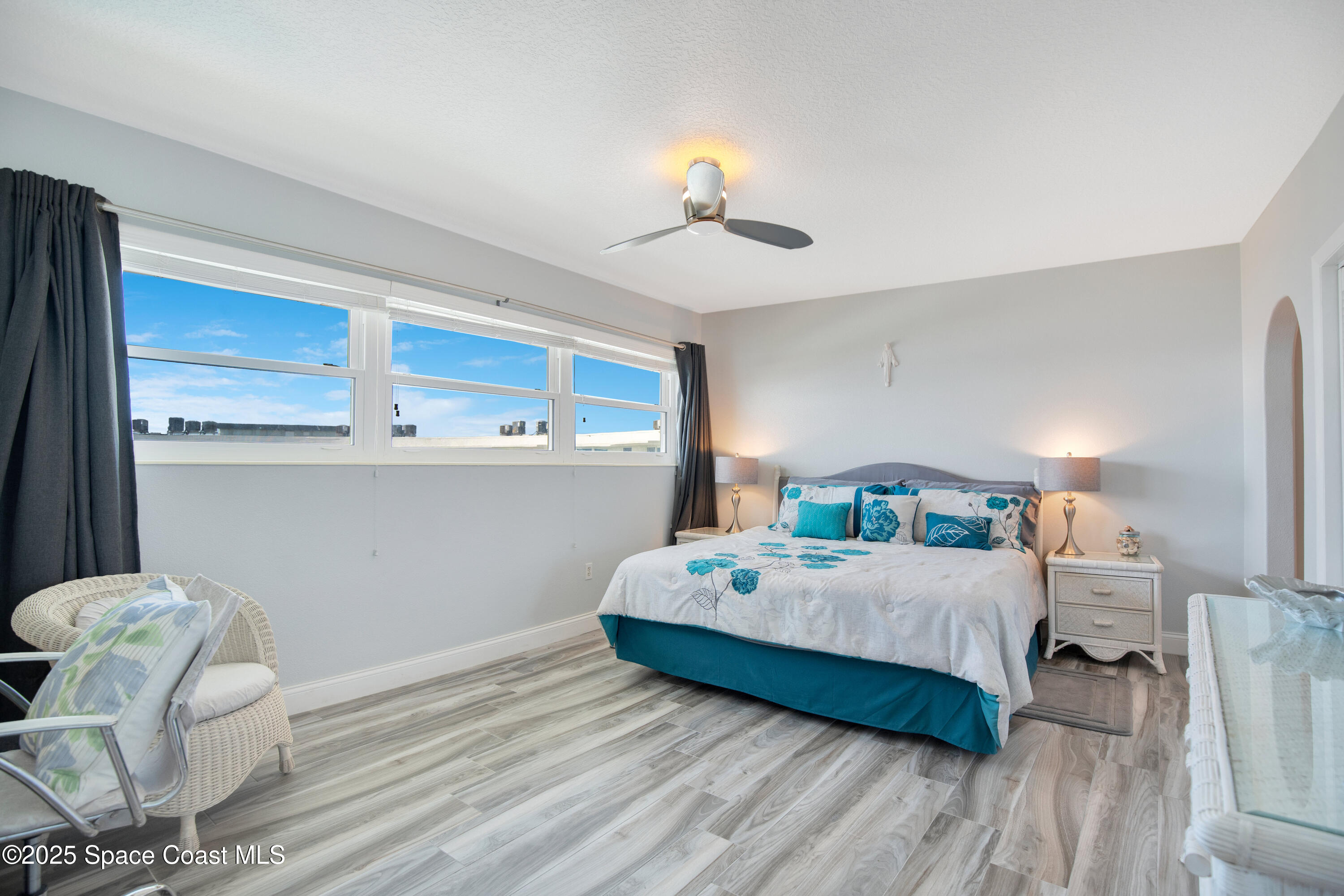 4000 Ocean Beach Boulevard, Unit 5C Cocoa Beach, FL 32931 - Photo 10 of 32 a bedroom with a bed and a chandelier