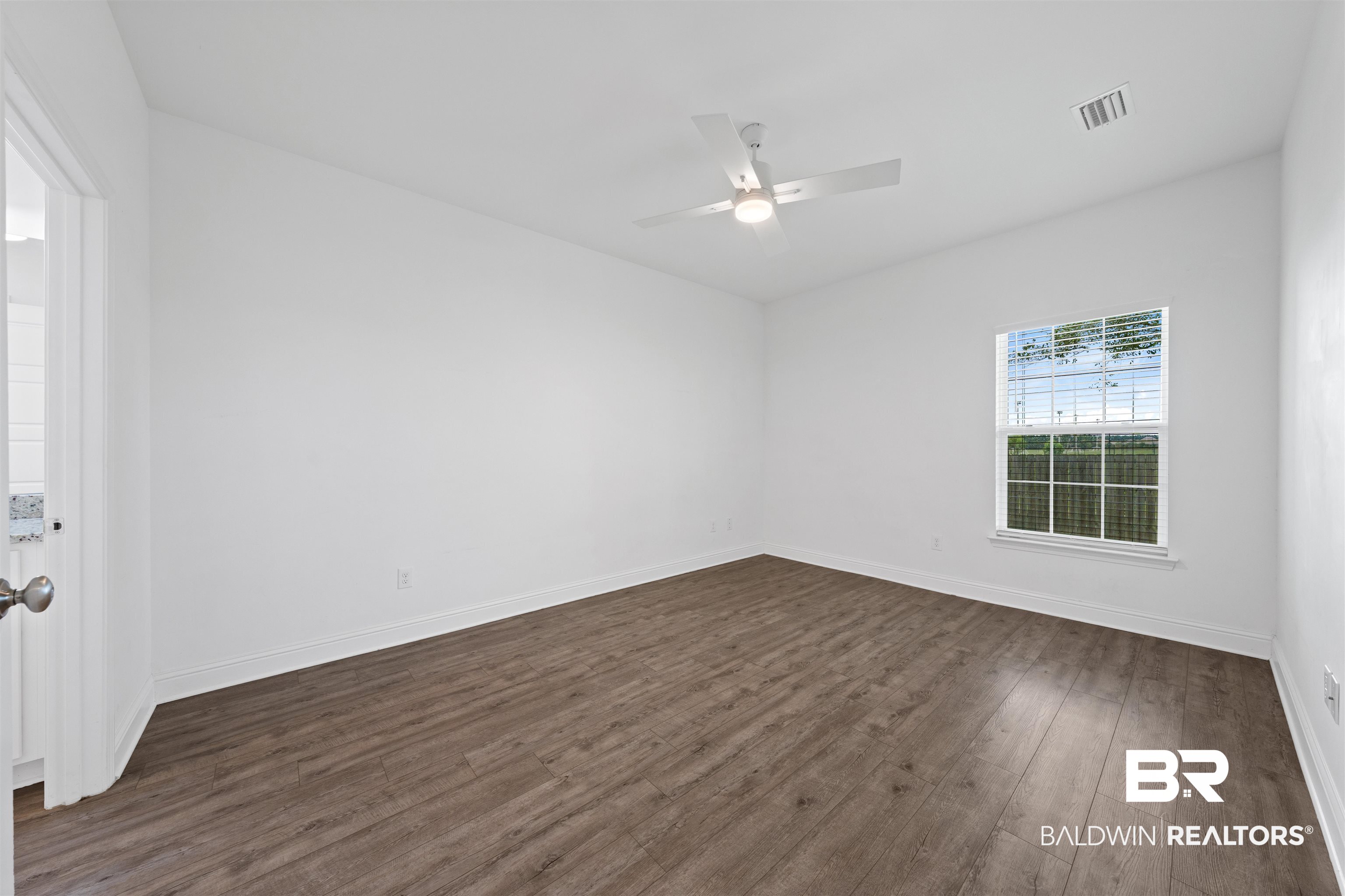 2651 South Juniper Street, Unit 1801 Foley, AL 36535 - Photo 11 of 16 Spacious interior room featuring wood-finish flooring, white baseboards, and bright white walls