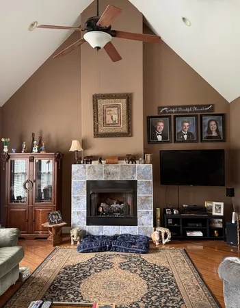 a living room with furniture a flat screen tv and a fireplace