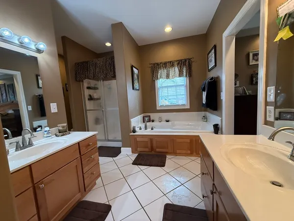 a large bathroom with a tub sink and mirror