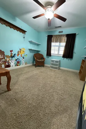 a view of a livingroom with furniture and a ceiling fan