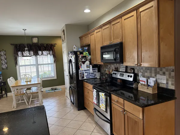 a kitchen with granite countertop a stove a sink and a microwave