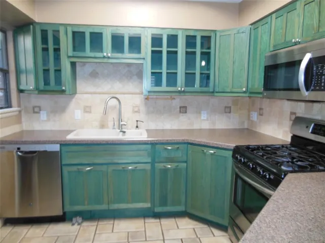 a kitchen with a sink a stove and cabinets