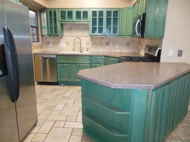 a kitchen with a sink cabinets and a refrigerator