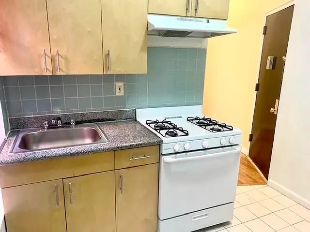 a kitchen with a sink and a stove top oven