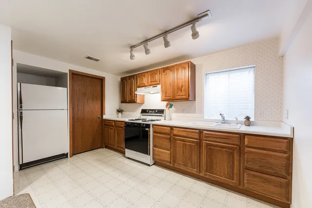 a kitchen with a sink stove and refrigerator