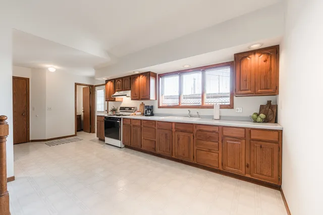 a kitchen with stainless steel appliances granite countertop a stove sink and cabinets
