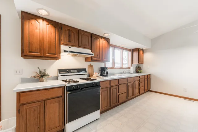 a kitchen with stainless steel appliances granite countertop a stove a sink dishwasher and a refrigerator