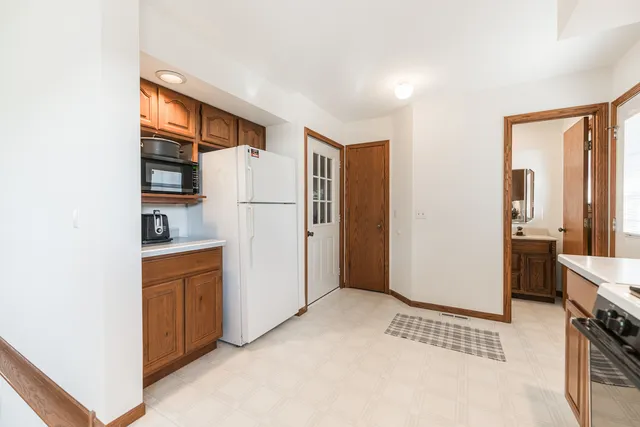 a view of a kitchen with refrigerator and wooden floor