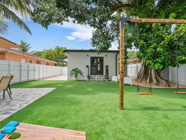 a view of a house with backyard and a tree