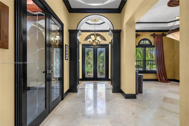 a view of a hallway with couches and chandelier