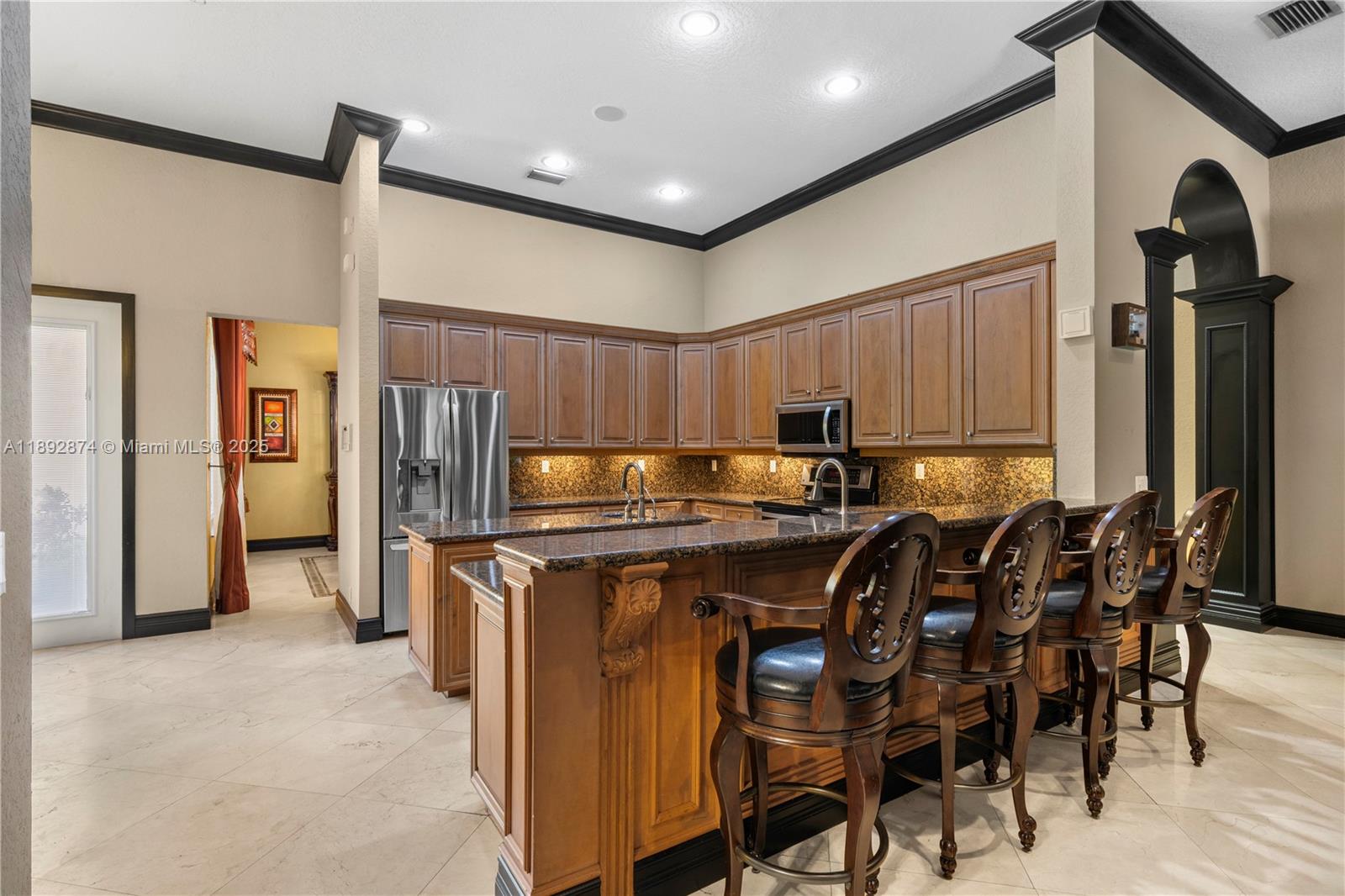 14130 Southwest 33rd Court Davie, FL 33330 - Photo 7 of 36 a kitchen with stainless steel appliances granite countertop a table chairs sink and refrigerator