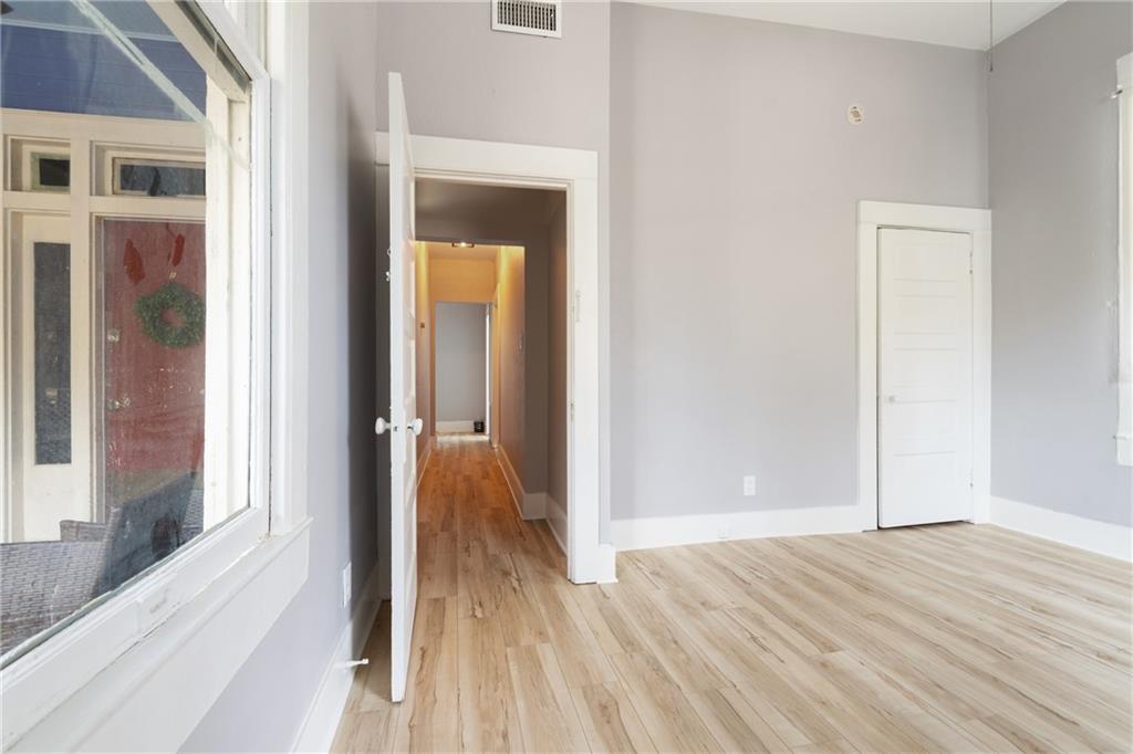 3210 Hampton Road, Unit A B C Austin, TX 78705 - Photo 37 of 42 Bright room featuring light wood-finish flooring, white baseboards, and a white interior door