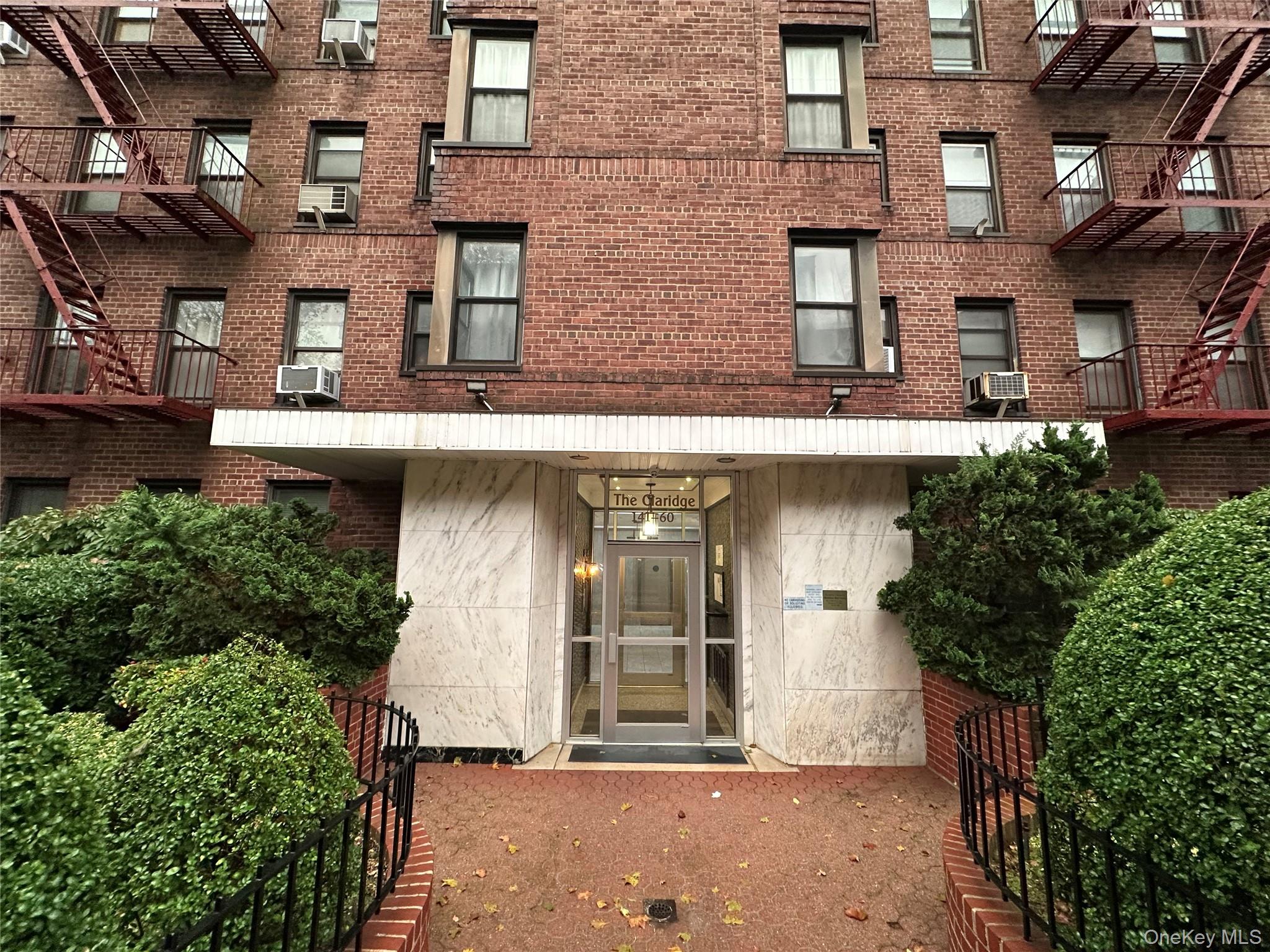 a front view of a building with plants