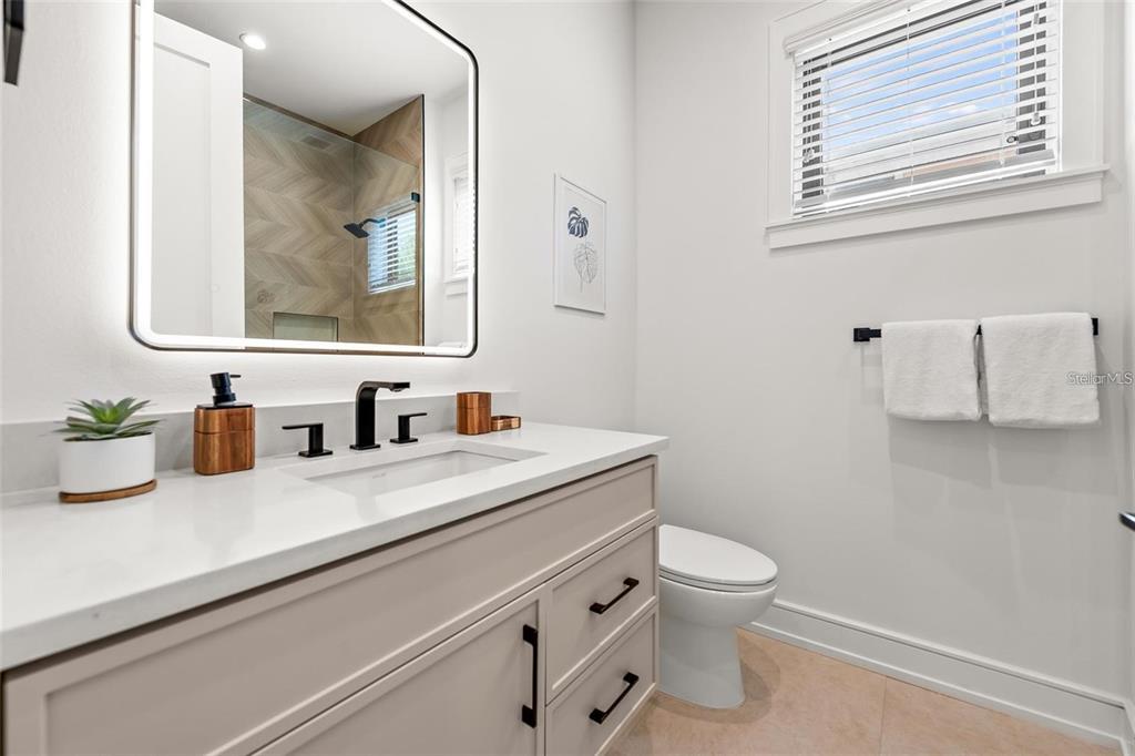 112 Maple Avenue Anna Maria, FL 34216 - Photo 26 of 91 a bathroom with a granite countertop toilet sink and mirror
