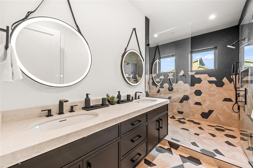 112 Maple Avenue Anna Maria, FL 34216 - Photo 30 of 91 a bathroom with a double vanity sink and a mirror