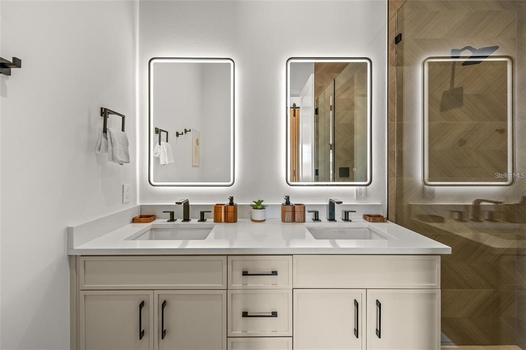 112 Maple Avenue Anna Maria, FL 34216 - Photo 53 of 91 a bathroom with double vanity sinks and a mirror