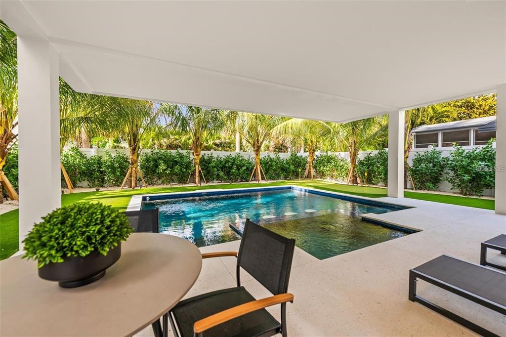 112 Maple Avenue Anna Maria, FL 34216 - Photo 68 of 91 a view of a swimming pool with a lounge chairs