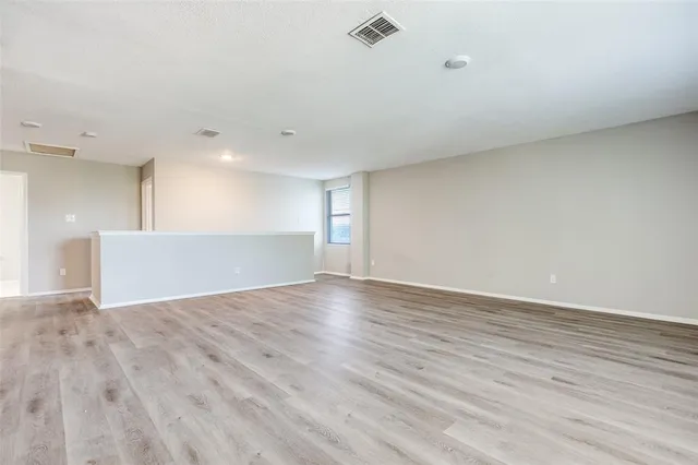 a view of an empty room with wooden floor
