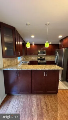 a view of kitchen with granite countertop cabinets and sink