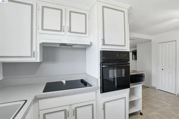a kitchen with white cabinets and stainless steel appliances