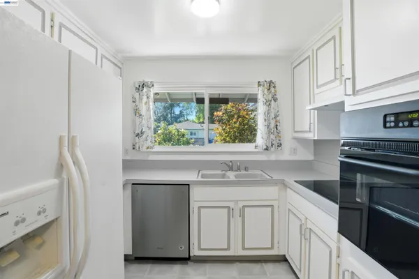 a kitchen with white cabinets and a stove