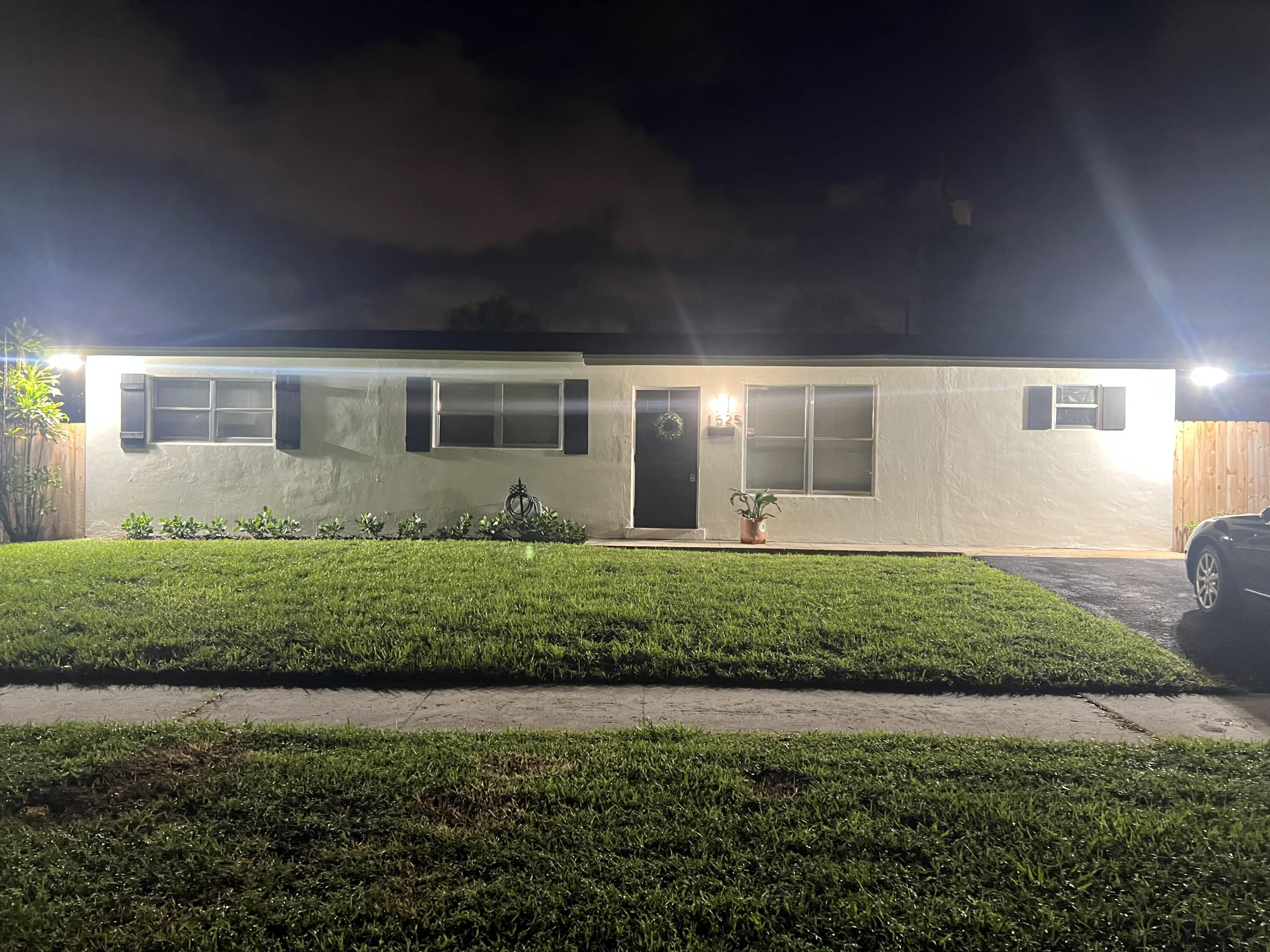 1525 Pine Tree Court Riviera Beach, FL 33404 - Photo 1 of 1 a front view of a house with a garden