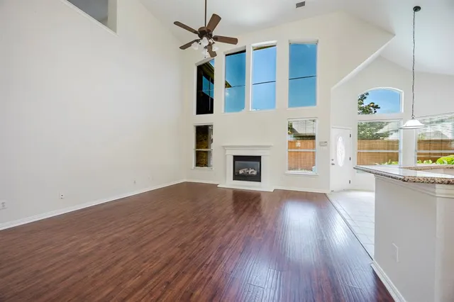 a view of a livingroom with wooden floor and a ceiling fan