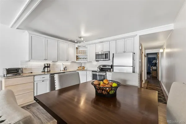 a kitchen with stainless steel appliances granite countertop a stove refrigerator and cabinets