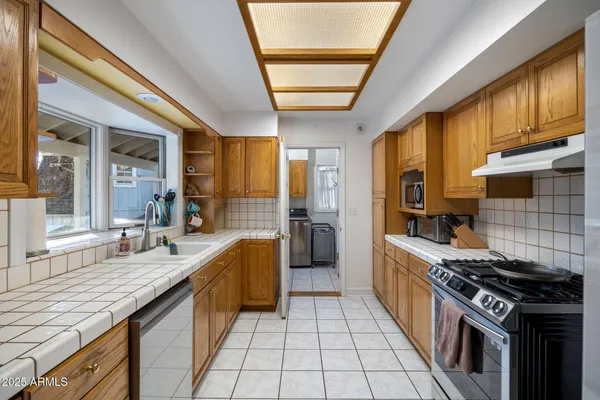 a kitchen with stainless steel appliances granite countertop a stove refrigerator and cabinets
