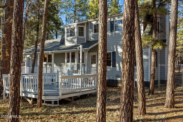 a view of a brick house with a large window and wooden fence