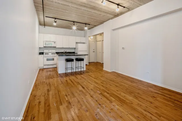 a kitchen with a sink and wooden floor