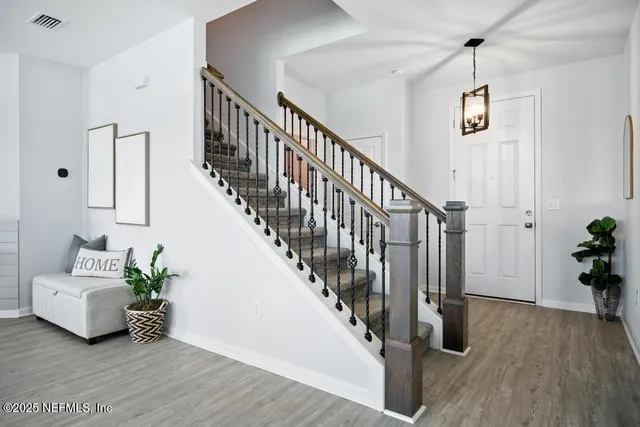 a living room with wooden floor and stairs