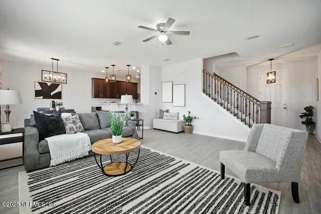 a living room with furniture a chandelier and a rug