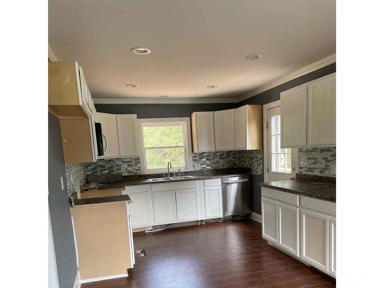 50 Henderson Road Roxboro, NC 27573 - Photo 5 of 6 a kitchen with granite countertop a sink and wooden cabinets