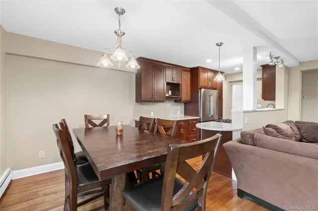 a bedroom with a bed and dresser with wooden floor