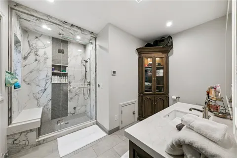 a living room with stainless steel appliances furniture a refrigerator and a glass door