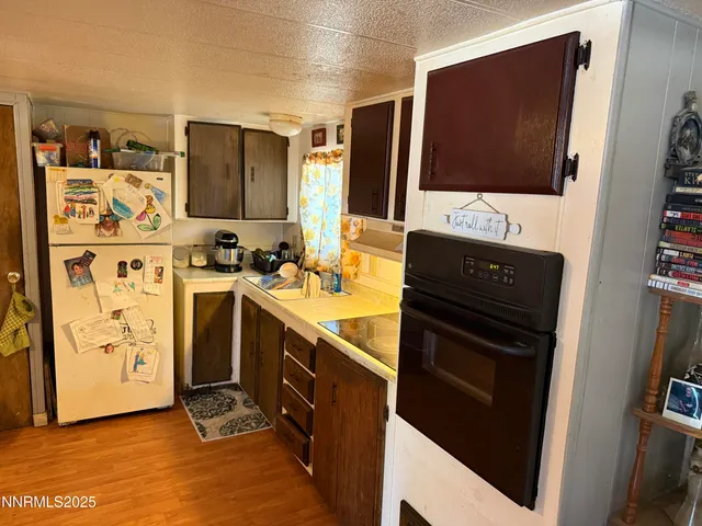 a view of a kitchen with fridge and wooden floor