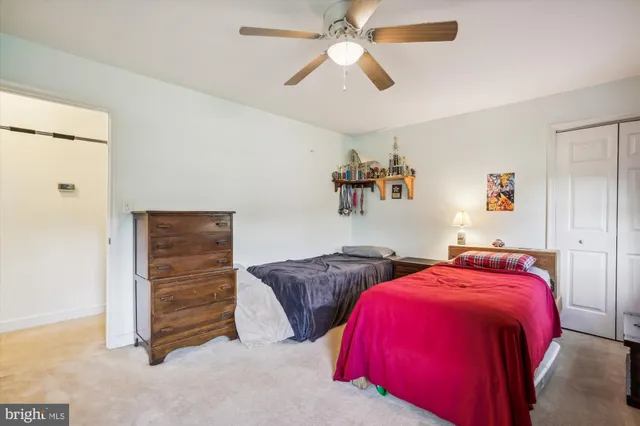 a bedroom with two bed and a ceiling fan