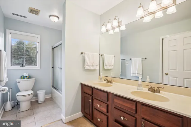 a bathroom with a double vanity sink toilet and a mirror