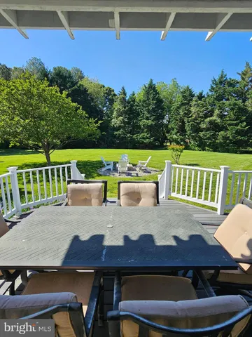 a view of a patio with table and chairs a barbeque with wooden floor and fence